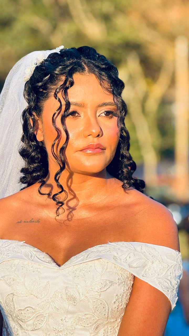 Retrato da noiva com véu, cabelos cacheados e luz dourada do fim de tarde