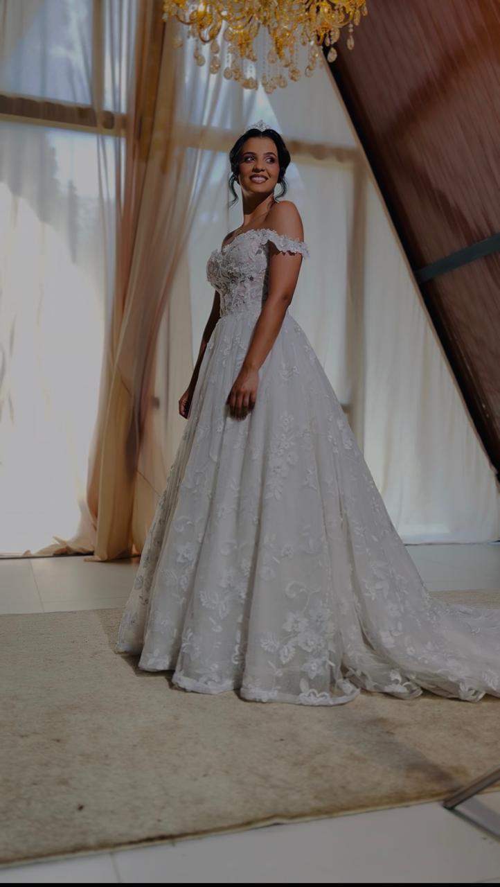 Noiva de vestido longo bordado em um salão iluminado